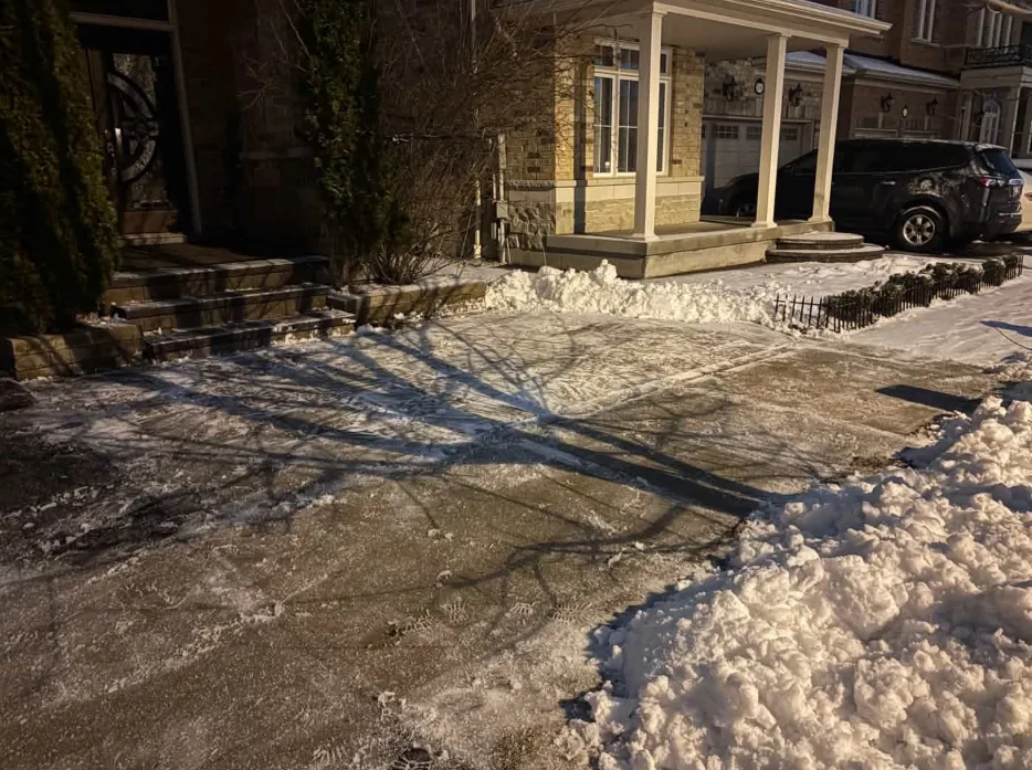 Front walkway and steps cleared of snow beside residential porches in Toronto, Ontario