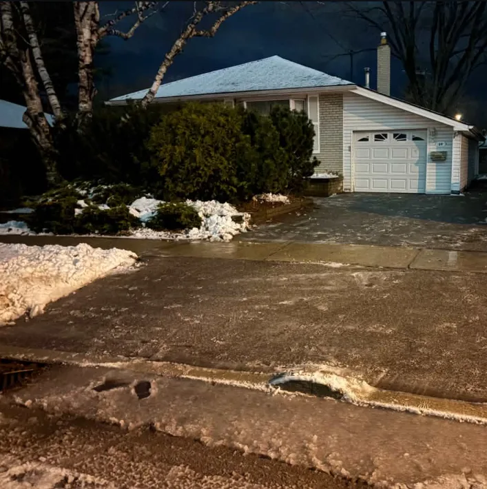 Cleared driveway leading to a detached garage with snow along its edges in Durham Region, Ontario