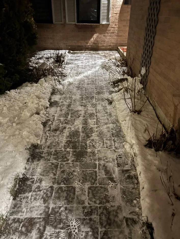 Paver entrance walkway cleared of snow beside a brick home in Durham Region, Ontario